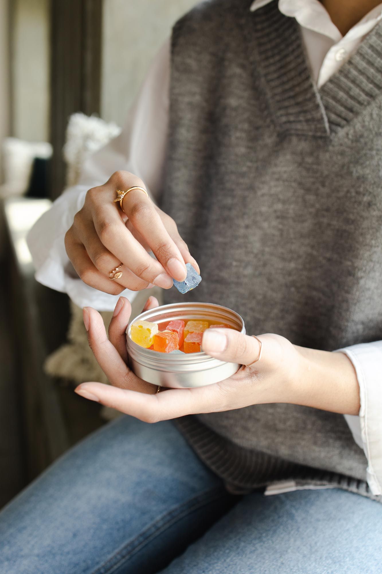 woman holding tin of gummies